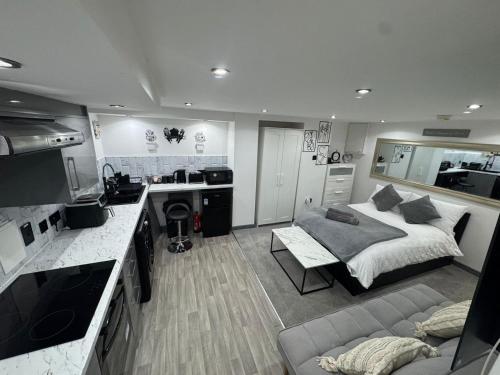 a bedroom with a bed and a kitchen with a couch at Royal Noor Escape in Killingbeck