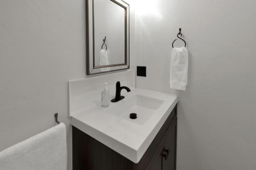 a white bathroom with a sink and a mirror at Tejas Suite Walking Distance to Main St! in Fredericksburg