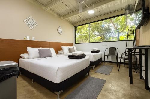 a bedroom with two beds and a large window at Malibu loft hotel in Medellín