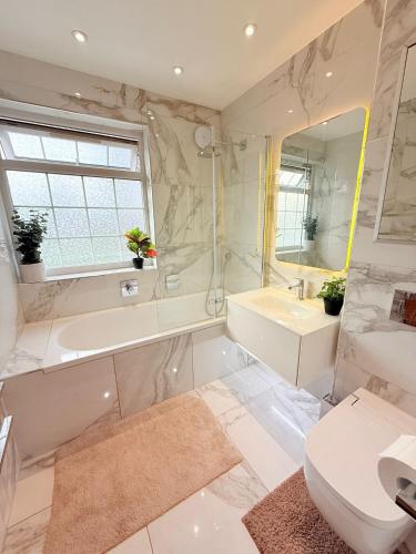 a bathroom with a tub and a sink and a toilet at 10 Minutes to Wembley Stadium Guest Rooms in London