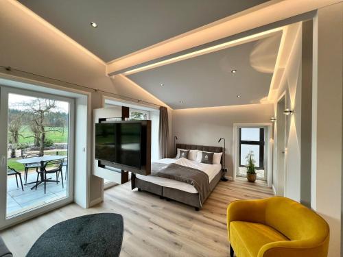 a bedroom with a bed and a large screen tv at Hotel LandGut & Residenz DRIEHOF in Tecklenburg