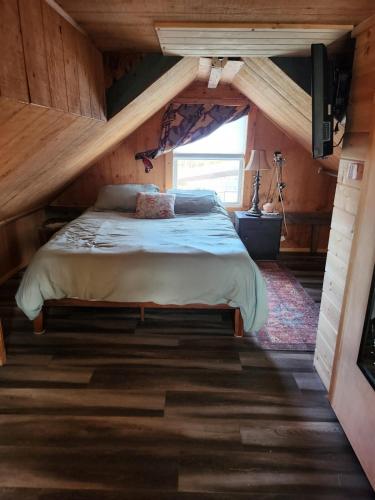 a bedroom in a log cabin with a bed at Cable Head Oceanview Casita in Saint Peters