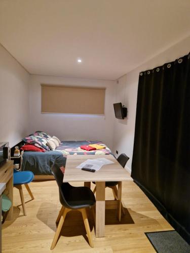 a room with a desk and a bed and a table at Tiny House, 12mn du Parc, Terrasse & Clim in Châteaumur