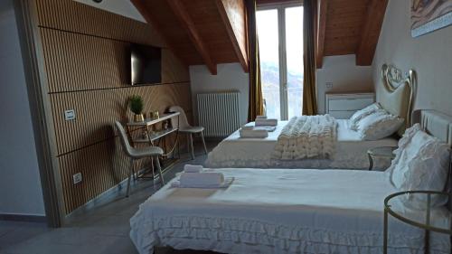 a bedroom with two beds and a table and chairs at Luna di miele in Albosaggia