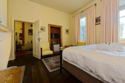 a bedroom with a bed and a window and a chair at Edinburgh Gallery Bed & Breakfast in Hobart