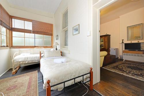 a bedroom with a bed and a tv in it at Edinburgh Gallery Bed & Breakfast in Hobart