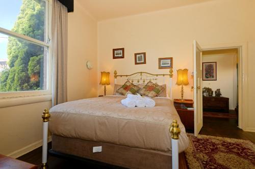 a bedroom with a bed with two towels on it at Edinburgh Gallery Bed & Breakfast in Hobart