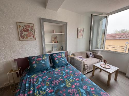 a bedroom with a bed and a couch and a window at Hirondelles 3 in Eugénie-les-Bains