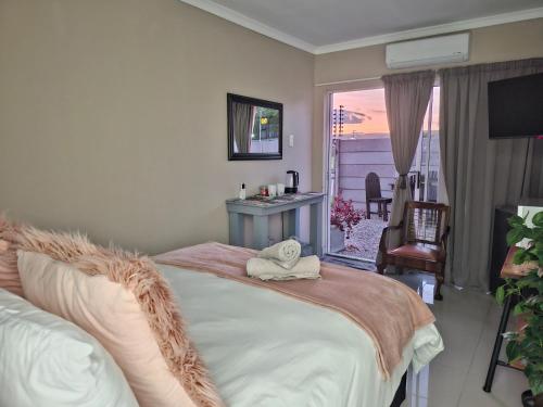 a bedroom with a large bed and a balcony at Addo River Den in Gqeberha