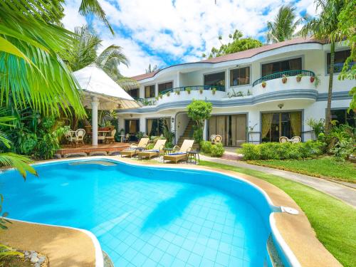 a swimming pool in front of a house at Villa Sunset Boracay in Boracay