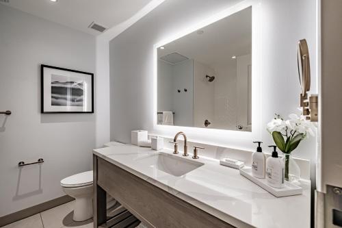 a white bathroom with a sink and a toilet at Hotel Bridgton in Bridgton