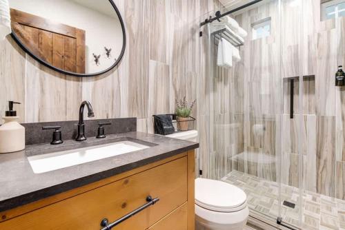 a bathroom with a sink and a toilet and a mirror at Southern Charm - Near Main With Hot Tub in Fredericksburg