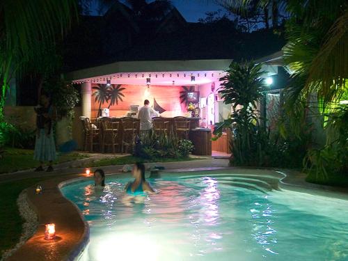 a man standing in a swimming pool at night at Villa Sunset Boracay in Boracay