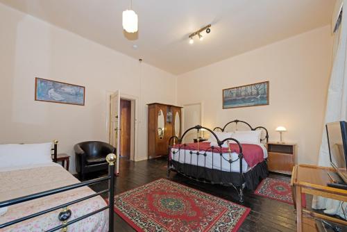 a bedroom with two beds and a chair in it at Edinburgh Gallery Bed & Breakfast in Hobart