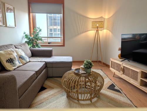 a living room with a couch and a tv at 3D Apartamento a 3 minutos da praia in Matosinhos