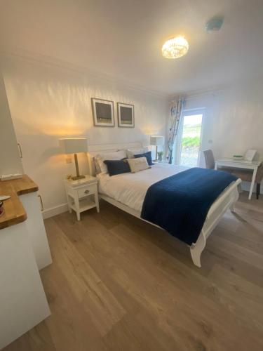 a bedroom with a large bed with a blue blanket at Watermark Luxury Accommodation in Portmagee