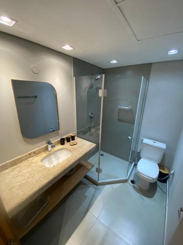 a bathroom with a toilet and a sink and a shower at Flat em Alphaville - Super Novo in Barueri