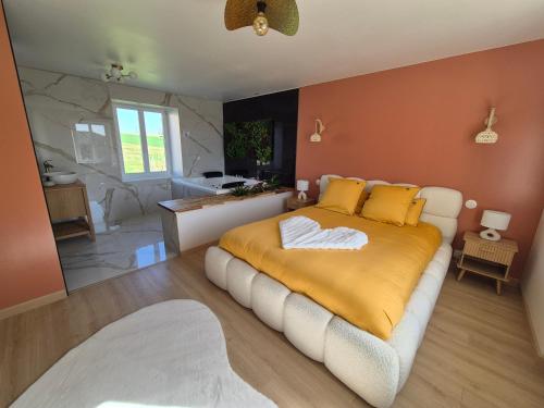 a bedroom with a large bed with yellow sheets at La clé des songes in Cellefrouin