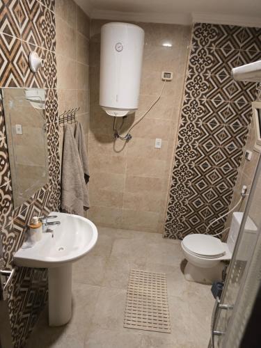 a bathroom with a toilet and a sink at Modern 3BR Apartment - Heart of Sheikh Zayed - Gated Compound in Sheikh Zayed