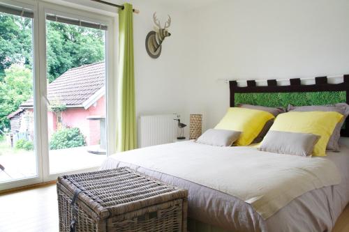 - une chambre avec un grand lit et une grande fenêtre dans l'établissement Chambres d'hôtes Souffle Nature, à Montenois