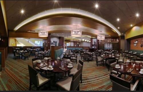 a dining room with tables and chairs in a restaurant at Apache Casino Hotel in Lawton