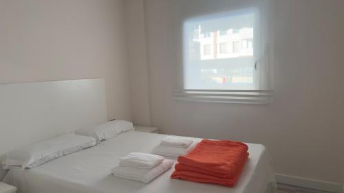 a white room with towels sitting on a bed at Turquesa 10 in La Pineda