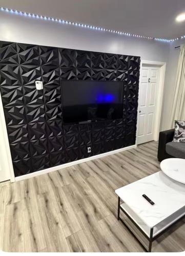 a living room with a flat screen tv on a wall at EWRBNB- Private bedroom in a Well Spaced Shared Apartment 4 in Elizabeth