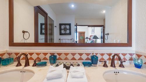 a bathroom with two sinks and a large mirror at Vacation Paradise Relaxing Ocean Front Condo in Puerto Peñasco