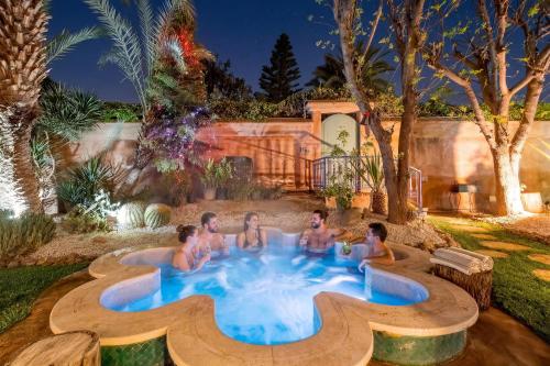 a group of men sitting in a pool in a backyard at Luxury Private Villa Taj Sofia & Spa in Marrakesh
