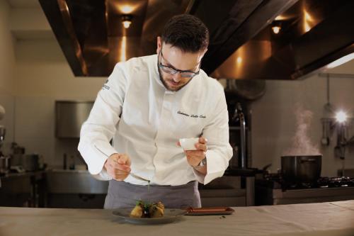 a man in a kitchen preparing a plate of food at Le Conche country house in Villamaina