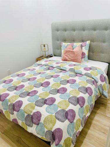 ein Schlafzimmer mit einem Bett mit einer farbenfrohen Bettdecke in der Unterkunft Charming Full Basement Unit in Hamilton