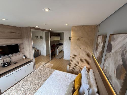 a bedroom with a large bed and a bathroom at Flat Completo Granja Brasil in Petrópolis