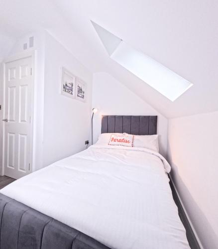 a bedroom with a large white bed with a skylight at D- Cosy Private Ensuite Sheffield Centre in Victoria