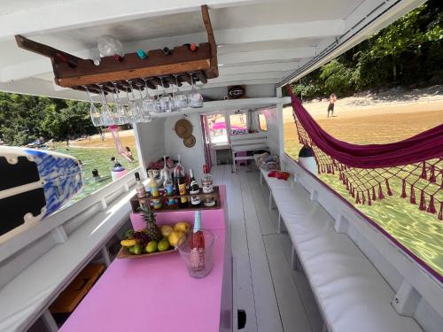 a bar on a boat with a view of the beach at Vibe in Paraty