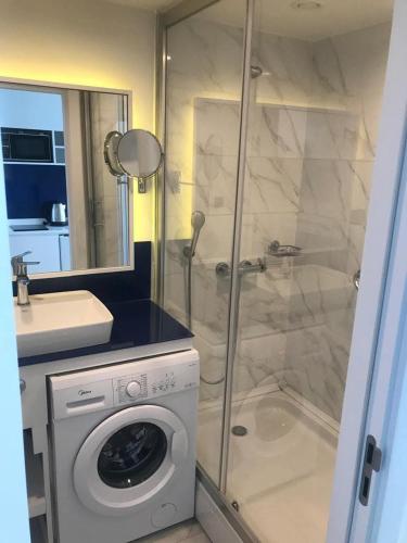 a bathroom with a shower and a washing machine at VIP HOTEL Sea view in batumi R in Batumi