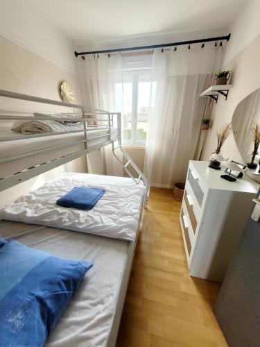 a bedroom with two bunk beds and a desk at Duplex les pieds dans l'eau in Grandcamp-Maisy