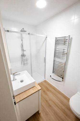 a white bathroom with a shower and a sink at Family Apartment near Mölltaler Gletscher 2 in Flattach