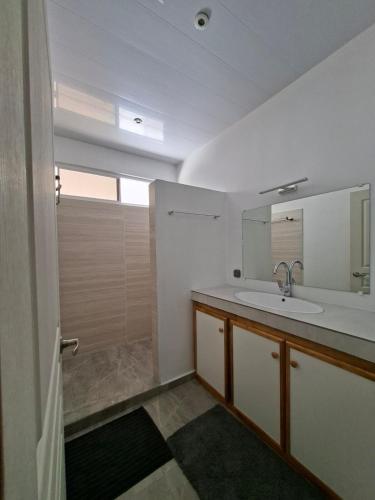 a bathroom with a sink and a mirror at Bungalow Miti in Uturoa