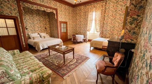 a bedroom with two beds and a couch and a table at Château de Busset in Busset
