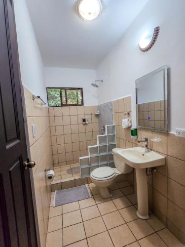 a bathroom with a toilet and a sink at Hotel Manuel Antonio Beracha in Quepos