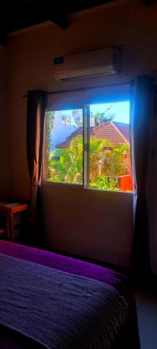 a bedroom with a window with a view of a house at Altocostanera in Posadas