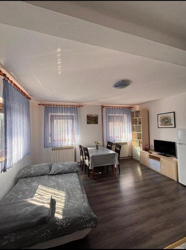 a bedroom with a bed and a table in it at Apartment Goran in Poljanak