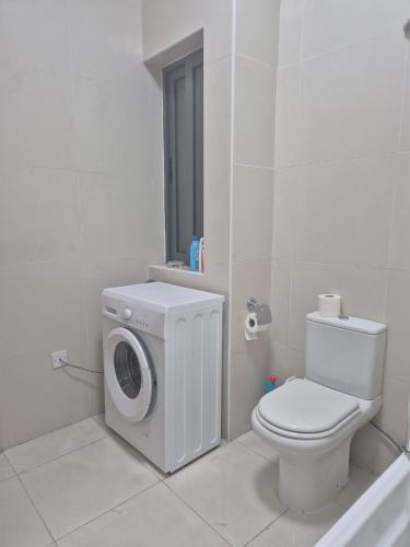 a bathroom with a washing machine and a toilet at Central 1 BR Retreat in Il-Gżira