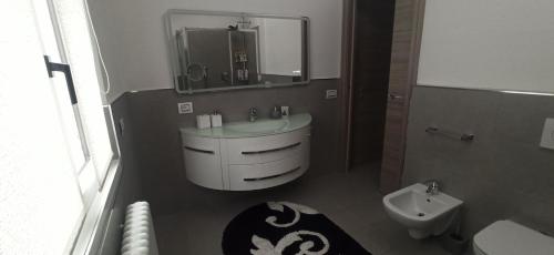 a bathroom with a sink and a toilet and a mirror at Luna di miele in Albosaggia