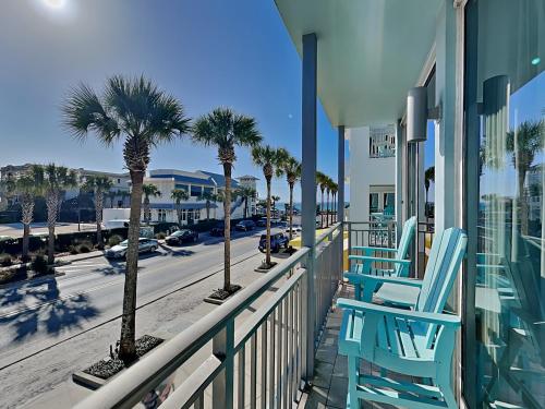 two blue chairs on a balcony with palm trees at Gulf Place Six Palms #2B - BBs Hideaway in Santa Rosa Beach