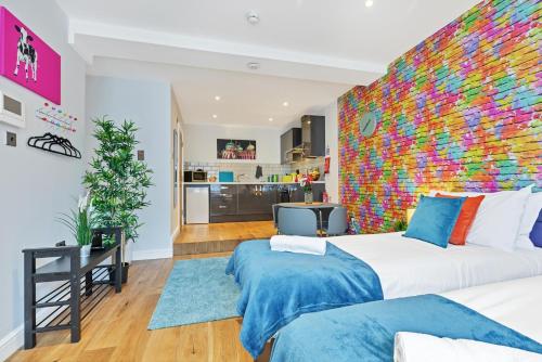 a bedroom with a large bed with a colorful wall at Rainbow Studio By My Getaways in Brighton & Hove