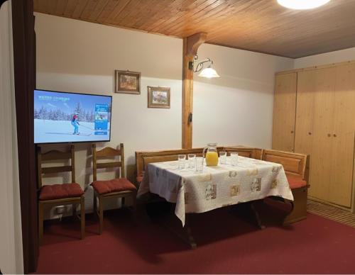 a dining room with a table and a tv at Soldanella Cervinia apartment Vda Vacanze in Vetta CIR 0253 in Breuil-Cervinia