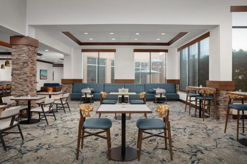 a lobby with tables and chairs and windows at Hilton Garden Inn Fort Worth Medical Center in Fort Worth