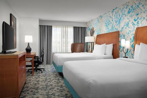 a hotel room with two beds and a flat screen tv at Hilton Garden Inn Fort Worth Medical Center in Fort Worth