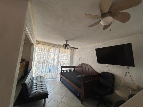a living room with a couch and a flat screen tv at Suite Villas Palmas Diamante in Acapulco